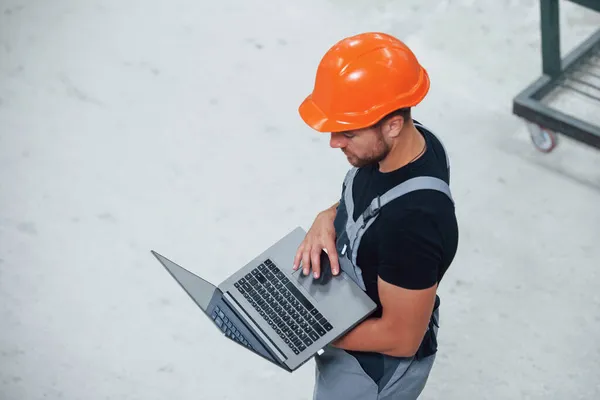 空中风景 手提电脑在手上 工厂里的产业工人 戴着橙色硬礼帽的年轻技师 — 图库照片