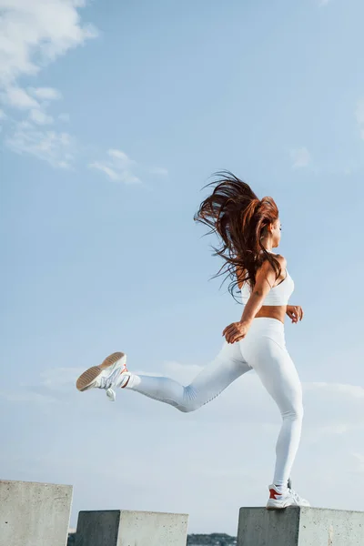 空の上だ フィットネスを行う白いスポーツ服の女性ランナー — ストック写真