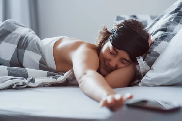 스마트폰 눈가리개를 여자가 아침에 침대에 있습니다 — 스톡 사진