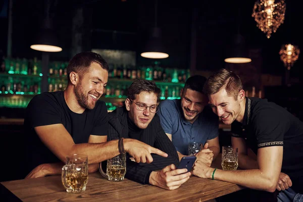 Αστείο Περιεχόμενο Στο Smartphone Τρεις Φίλοι Αναπαύονται Στην Παμπ Μπύρα — Φωτογραφία Αρχείου