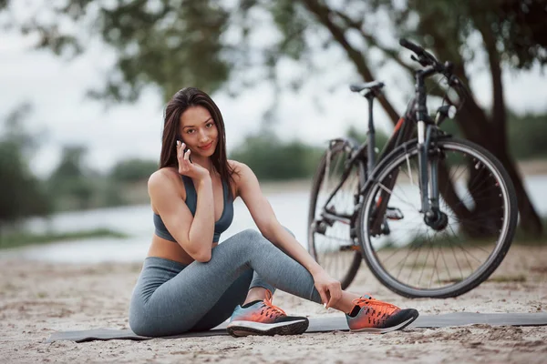 Haciendo Una Llamada Ciclista Femenina Con Buena Forma Corporal Sentada — Foto de Stock