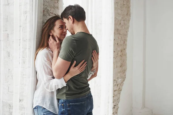 Preciosa Pareja Besándose Disfrutando Uno Del Otro Cerca Ventana Nuevo —  Fotos de Stock