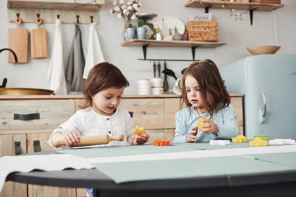 Dwoje Dzieci Bawiących Się Żółtymi Pomarańczowymi Zabawkami Białej Kuchni — Zdjęcie stockowe