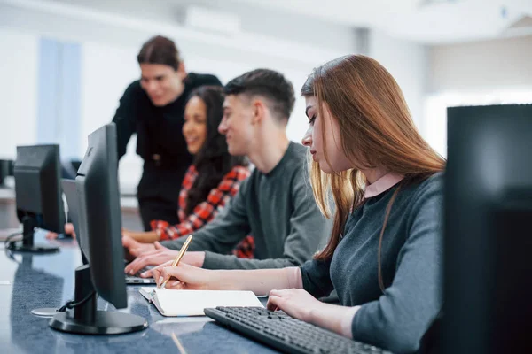 Herkes işini yapıyor. Modern ofiste sıradan kıyafetler giyen bir grup genç..