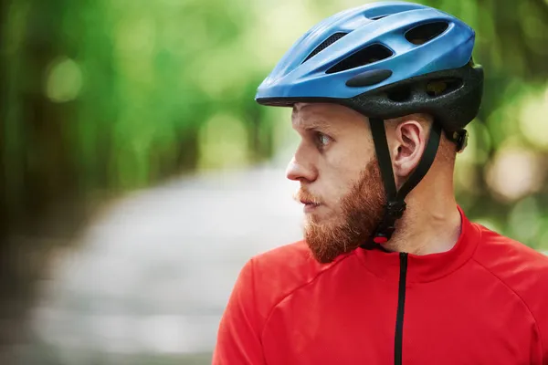 側を見て 自転車の上のサイクリストは晴れた日に森の中のアスファルトの道路にあります — ストック写真