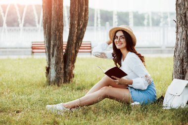 Güneş batmak üzere. Genç bir kadın hafta sonu geçirir ve gündüz vakti parkta oturur..