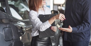 Tebrik ederim. Müdür yardımcısı otomobil salonundaki müşteriye danışmanlık ve yardım yapıyor.