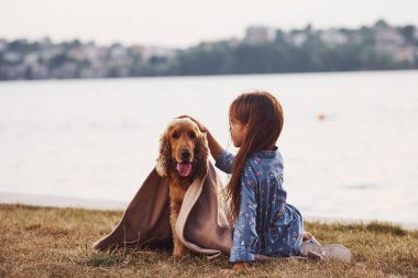 Rog 'u kullanarak. Şirin küçük kız, güneşli bir günde köpeğiyle dışarı çıkar..