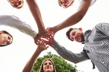 Açık havada başarılı arkadaşlardan oluşan genç bir ekibin ellerine yakından bakın..