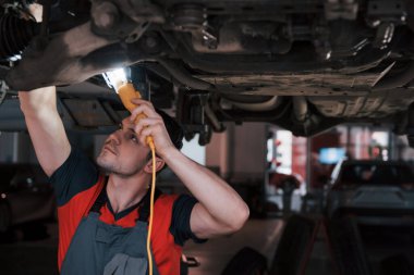 Sadece güçlü ellere değil, iyi bir görüşe de ihtiyaç var. Atölyedeki üniformalı adam modern arabanın kırık parçalarını tamir ediyor..