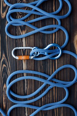 Bu şeyler kullanıma hazır. Tırmanma ekipmanlarının izole edilmiş fotoğrafı. Ahşap masada yatan karabinaların parçaları..