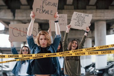 Sınır çizgisinin arkasında. Bir grup feminist kadın dışarıda hakları için protesto yapıyor..
