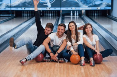 Olumlu duygular. Genç neşeli arkadaşlar hafta sonları bowling kulübünde eğleniyorlar..
