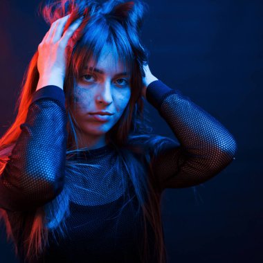 Güzel saç kesimi. Stüdyo karanlık stüdyoda neon ışıkla çekiliyor. Genç bir kızın portresi.