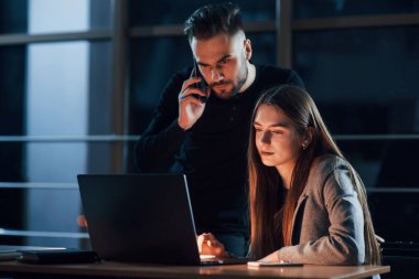 Telefonun başındaki konuşma. Genç iş adamlarından oluşan bir ekip gece ofiste projeleri üzerinde çalışıyor..