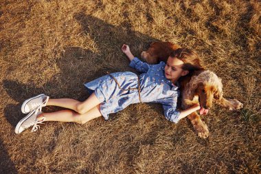 Üst Manzara. Çimlerin üzerinde yatıyordu. Şirin küçük kız, güneşli bir günde köpeğiyle dışarı çıkar..