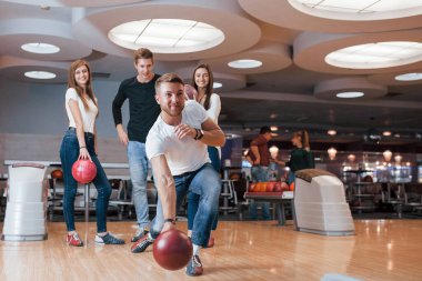 Güzel vücut şekli. Genç neşeli arkadaşlar hafta sonları bowling kulübünde eğleniyorlar..