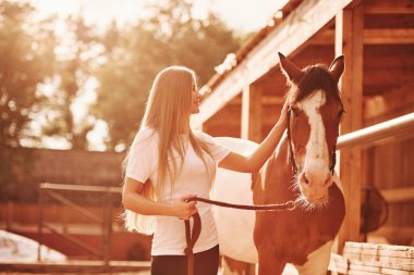 Kırsal kesimde. Gündüz vakti atıyla çiftlikte mutlu bir kadın.