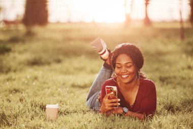 Telefonla. Yazın parktaki neşeli Afrikalı Amerikalı kadın..