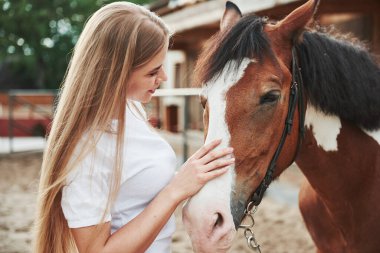 Sakin ve rahat. Gündüz vakti atıyla çiftlikte mutlu bir kadın.