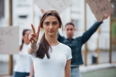 Arka plandaki arkadaşlar. Bir grup feminist kadın dışarıda hakları için protesto yapıyor..