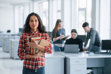 Ciddi ve kendinden emin. Modern ofiste çalışan günlük kıyafetli bir grup genç..