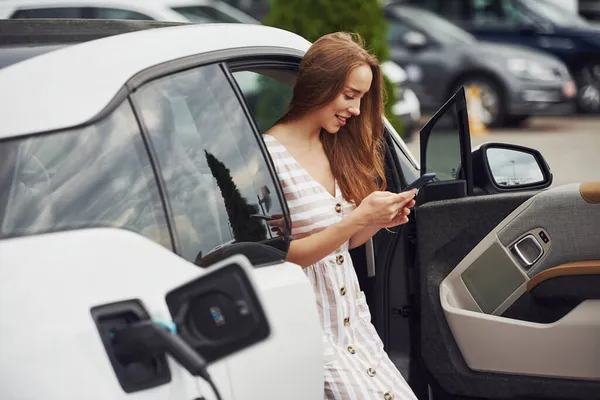 Telefonen Händerna Kvinna Elbilar Laddningsstation Dagtid Helt Nytt Fordon — Stockfoto