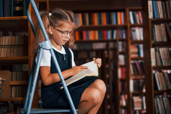 Schulmädchen Auf Der Leiter Der Bibliothek Voller Bücher Bildungskonzept — Stockfoto