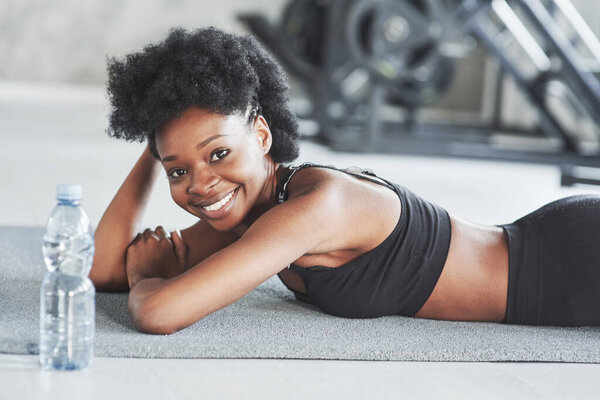 Getting ready for the exercises. African american woman with curly hair and in sportive clothes have fitness day in the gym.