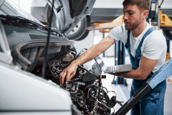 This part will cost. Employee in the blue colored uniform works in the automobile salon.