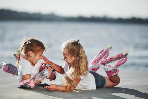 Lying Two Little Girls Roller Skates Outdoors Lake Background — Stock Photo, Image