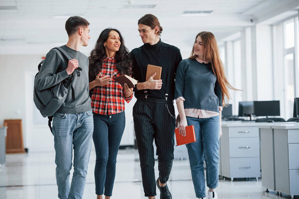 I had nice rest at my weekends. Group of young people walking in the office at their break time.