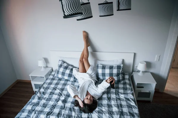거꾸로 가운을 새벽에 침대에 스마트폰을 사용하는 아름다운 — 스톡 사진