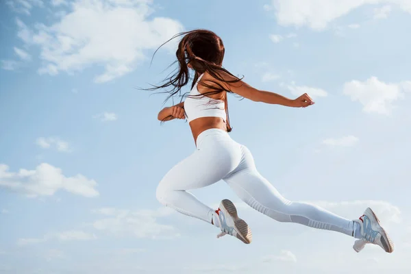 在天空中 身穿白色运动服的女赛跑选手健身 — 图库照片