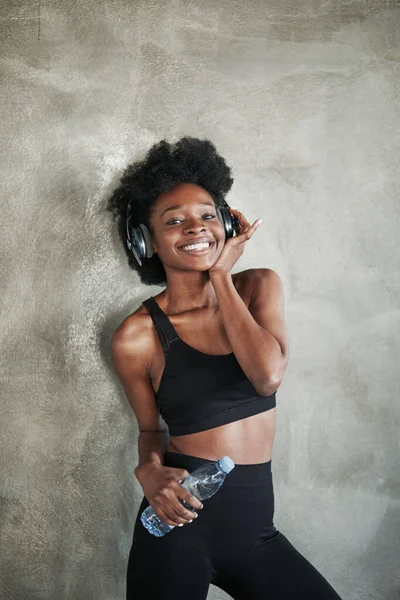 Pozitif dişi kendini tatmin olmuş hissediyor. Spor yaptıktan sonra spor kıyafetli Afrikalı Amerikalı bir kızın portresi..