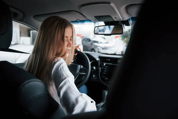 Vista Trasera Hermosa Chica Rubia Sentada Coche Nuevo Con Interior — Foto de Stock