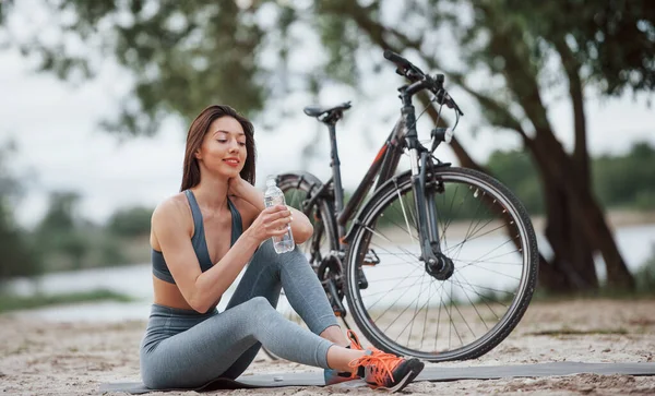 Pití Vody Žena Cyklistka Dobrým Tvarem Těla Sedí Blízkosti Svého — Stock fotografie