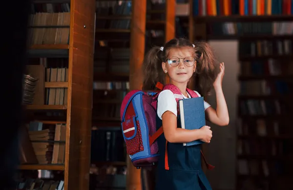 Милая Маленькая Девочка Рюкзаком Стоит Библиотеке Полной Книг Концепция Образования — стоковое фото