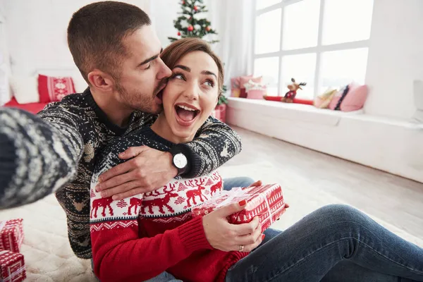 家族の写真 男は彼と彼の妻のクリスマスの服を着て 装飾的な美しい部屋の床に座って自撮り — ストック写真
