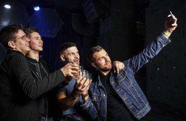 İnsanlar gece kulübünde eğleniyor. Ellerinde alkolle.