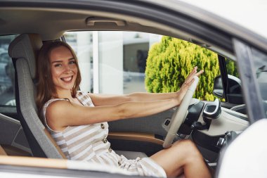 İyi hissettiriyor. Modern otomobilin içindeki kadın sürücü. Yepyeni araba deneniyor.