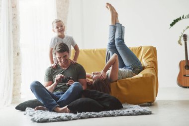 Kolay konuşma. Çocuklu genç bir çift kameranın çektiği resimlere bakıyor..