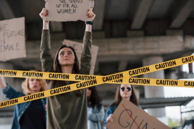 Yukarı bakıyorum. Bir grup feminist kadın dışarıda hakları için protesto yapıyor..