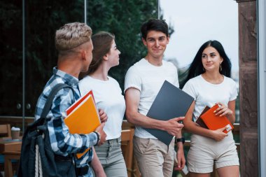 Gündelik giysiler içinde dört genç öğrenci yağmurlu bir günde buluşuyor..