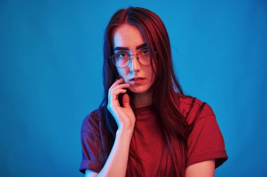 Kolay makyaj. Stüdyo içeride neon ışıkla çekiliyor. Güzel bir genç kızın portresi.