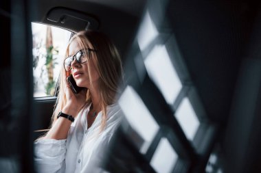 Bir tür soruna benziyor. Zeki iş kadını, siyah iç mekanı olan lüks arabanın arka koltuğunda oturur..