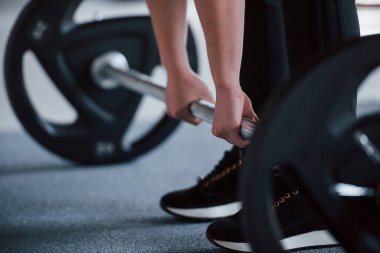 Kadının spor salonunda halterle çömelirken çekilmiş fotoğrafı..