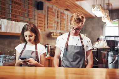 Ön manzara. İki genç kafe çalışanı içeride. İş ve hizmet kavramı.