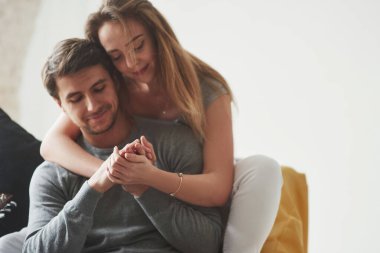 Ön manzara. Mutlu çift yeni evlerinin oturma odasındaki sarı kanepede dinleniyor..