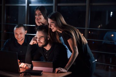 Geçen ayın sonuçları harika. Genç iş adamlarından oluşan bir ekip gece ofiste projeleri üzerinde çalışıyor..